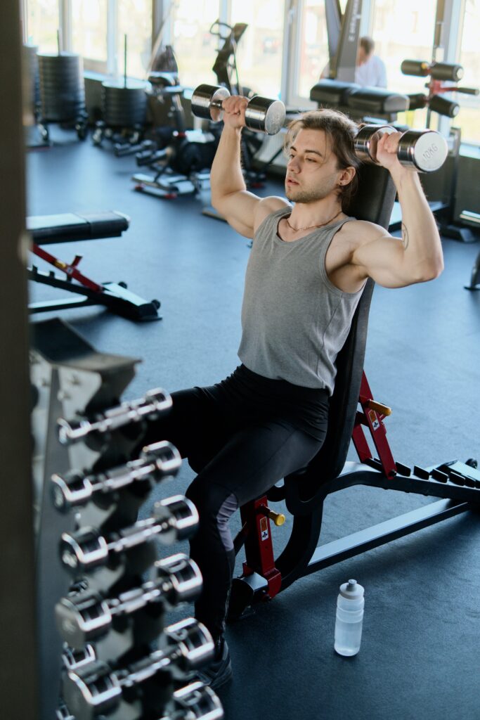 man doing a shoulder press to strengthen his shoulders and to avoid one of the 5 common hockey injuries, especially as a goalkeeper.